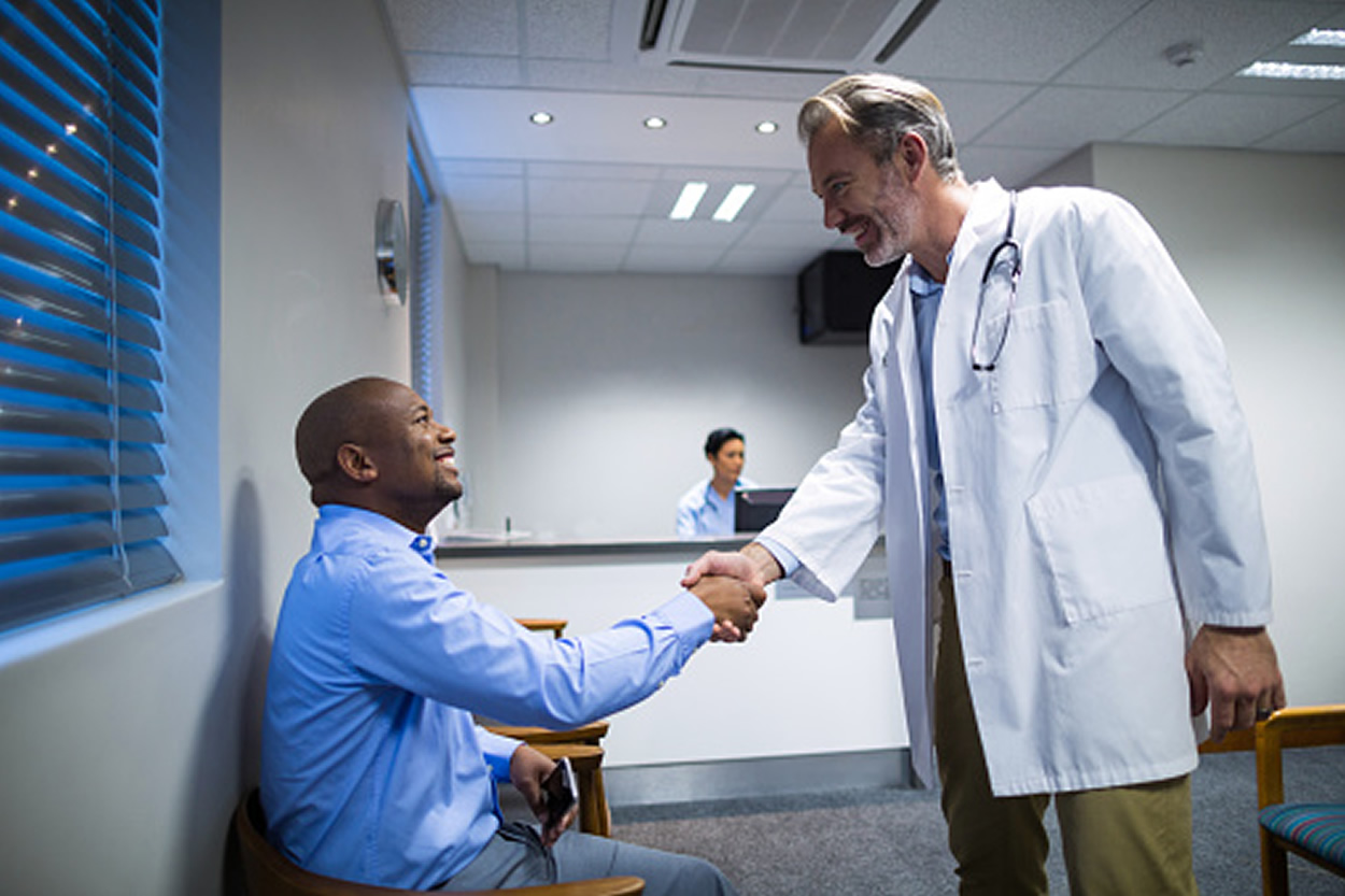 image of doctor shaking hands with patient in doctor's office