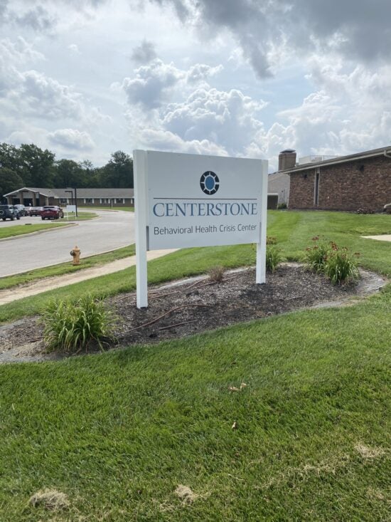 Centerstone Behavioral Health Crisis Center sign outside brick buildings beside a driveway.