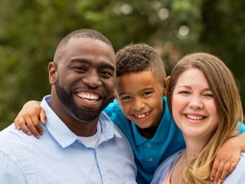 Smiling family picture with mom, dad and young child