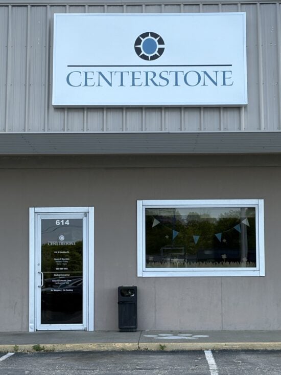 Centerstone sign above a glass entrance door marked 614, beside a window and accessible parking space.