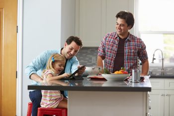 family in kitchen, girl looking at iPad