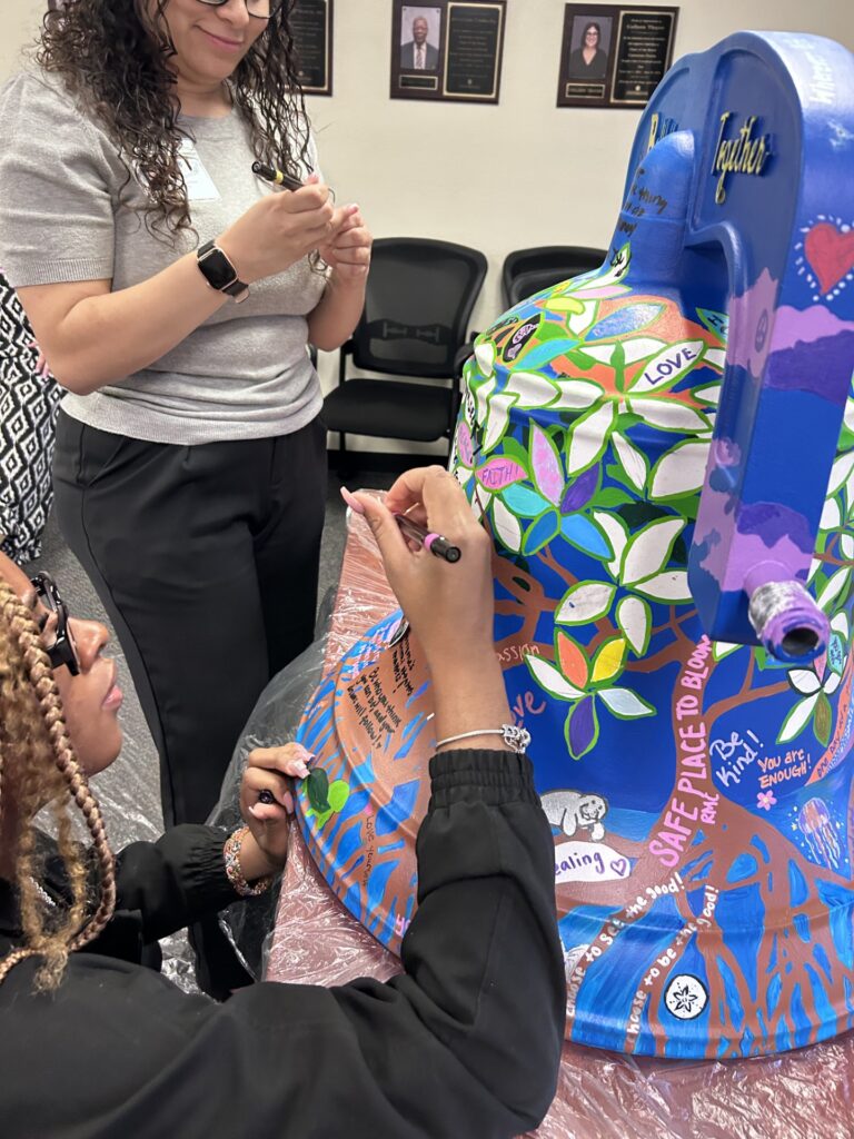 Centerstone team members paint a 3D bell.