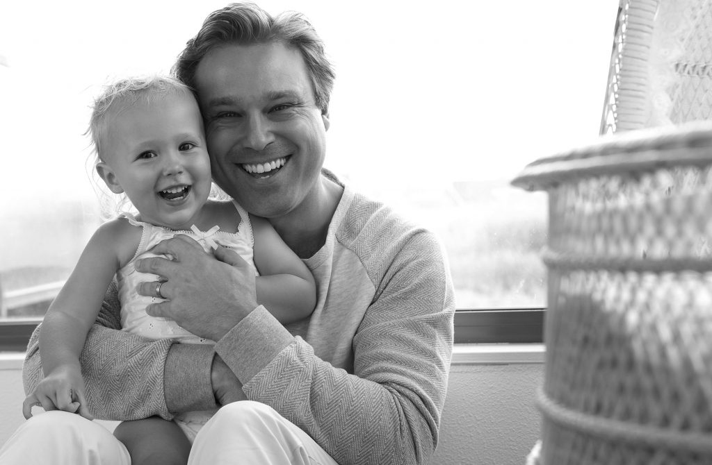 Cheerful father with cute baby laughing together