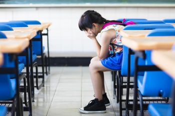 girl sitting on desk hands on knees