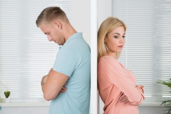 A man and woman on opposite sides of a door, after discovering an infidelity.