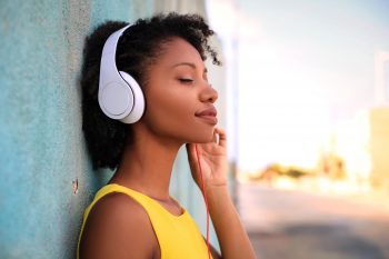 Smiling woman listening to soothing music with headphones