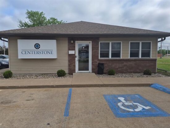 Centerstone building entrance with a large wall sign and an accessible parking space in front.
