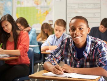 Classroom full of students writing in notebooks