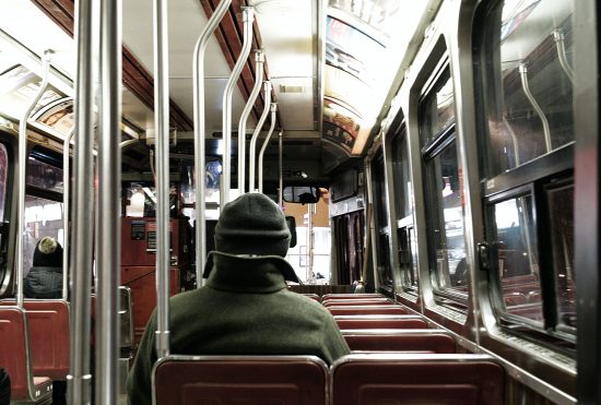 man dressed warm, alone in bus at night