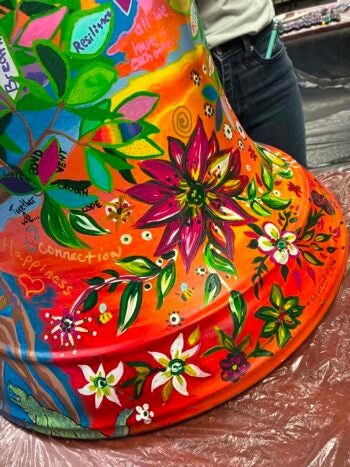 Artwork on a Be Well Bell depicts trees and flowers native to Sarasota, Florida.