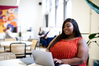 woman using laptop computer in a bright, open office workspace