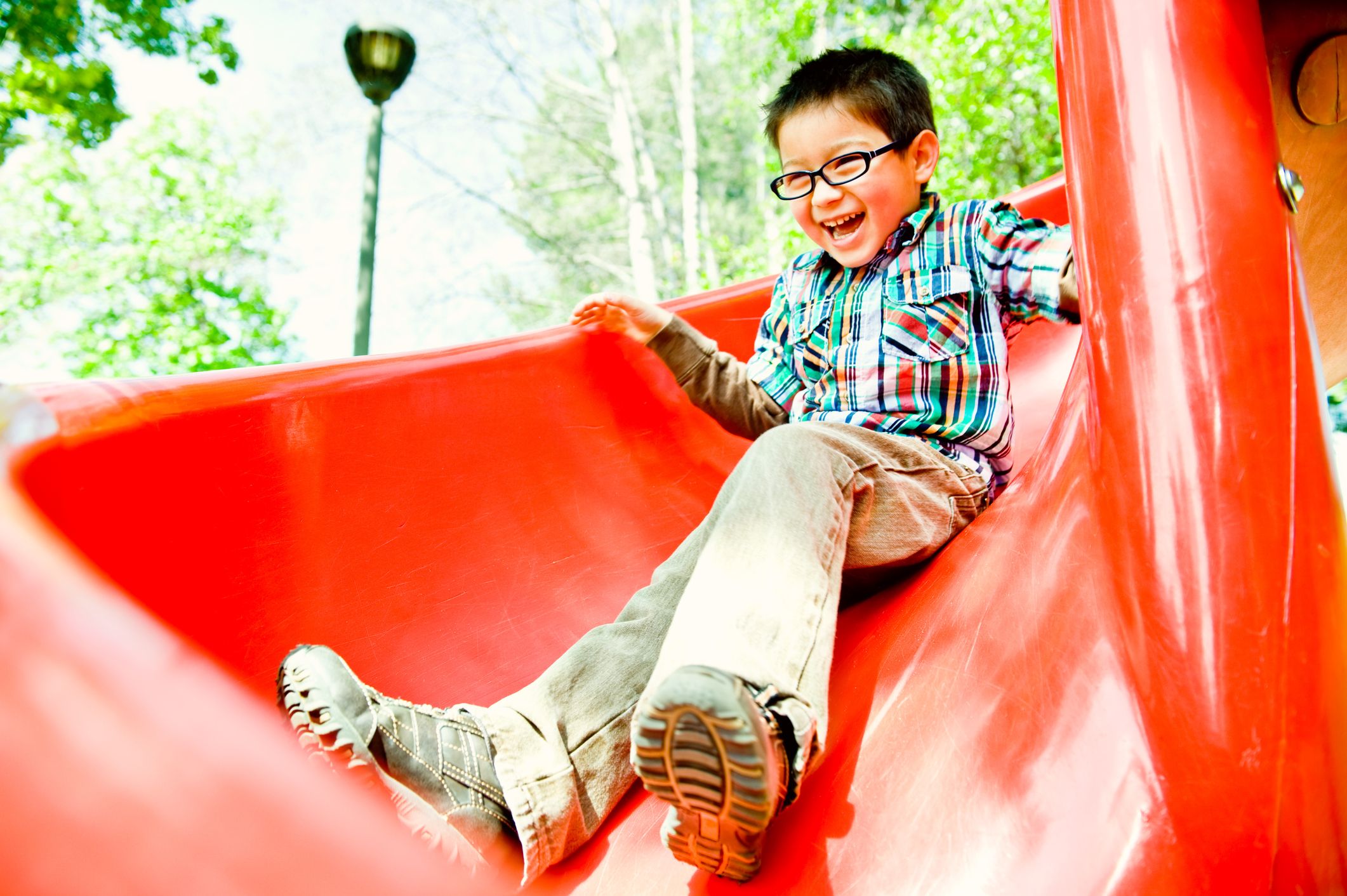 happy boy on red slide