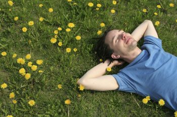 Man laying in grass, smiling