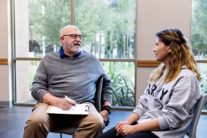 Therapist speaks and prepares to take notes during counseling session