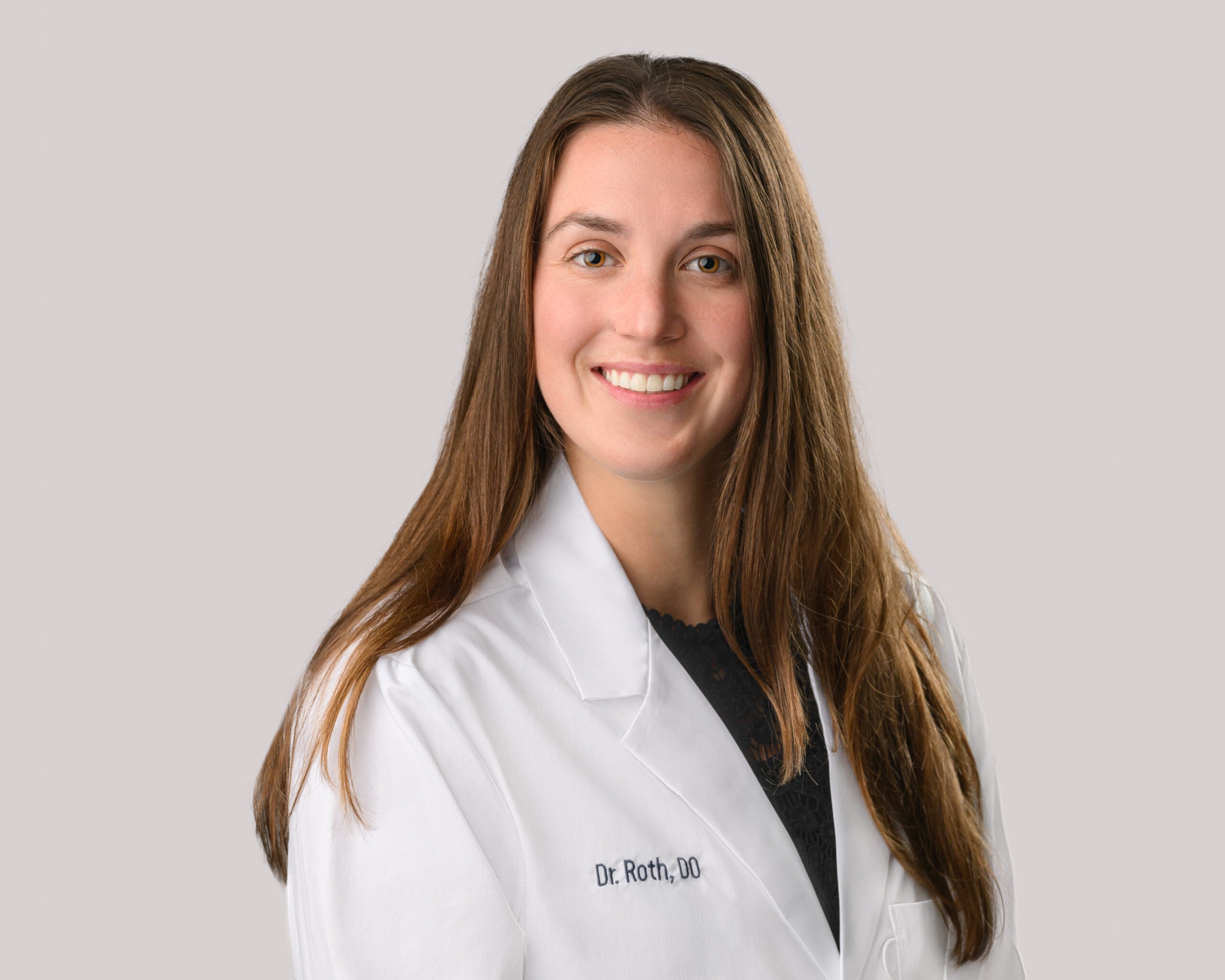 Portrait of Alex Roth, D.O. in a white lab coat