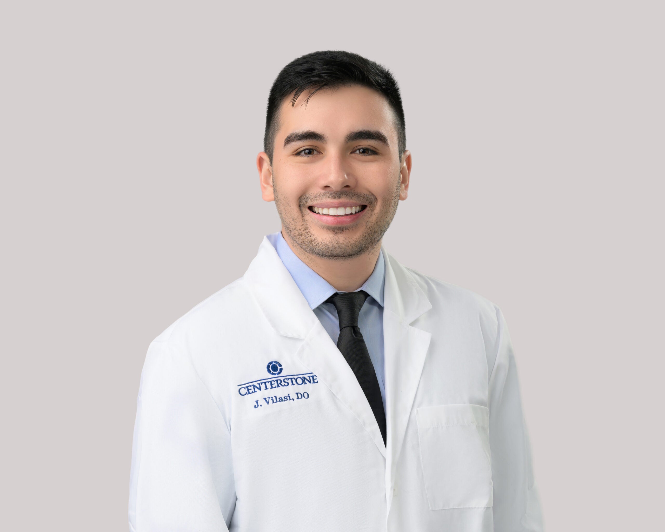 Portrait of Joseph Vilasi, D.O. in a white lab coat