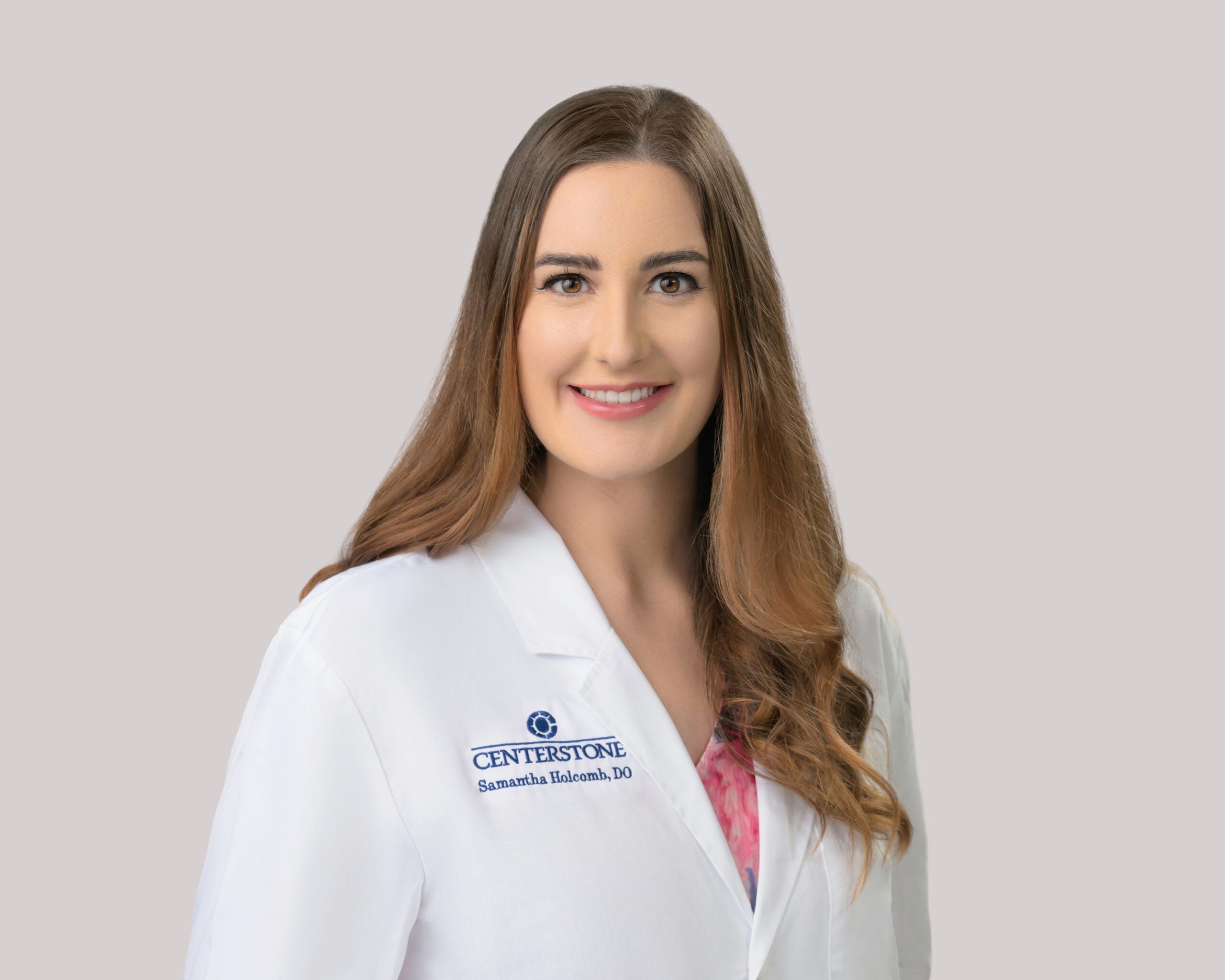 Portrait of Samantha Holcomb, D.O. in a white lab coat