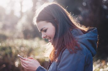 woman looking down at phone