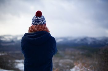 Person dressed warm staring into the wilderness