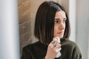 sad woman looking to the side holding tissue